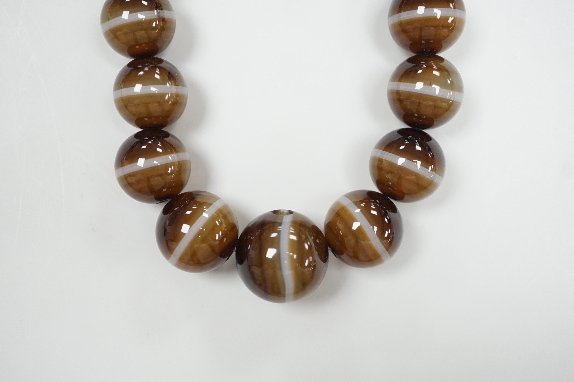 A single strand graduated banded agate circular bead necklace with yellow metal clasp, 46cm.